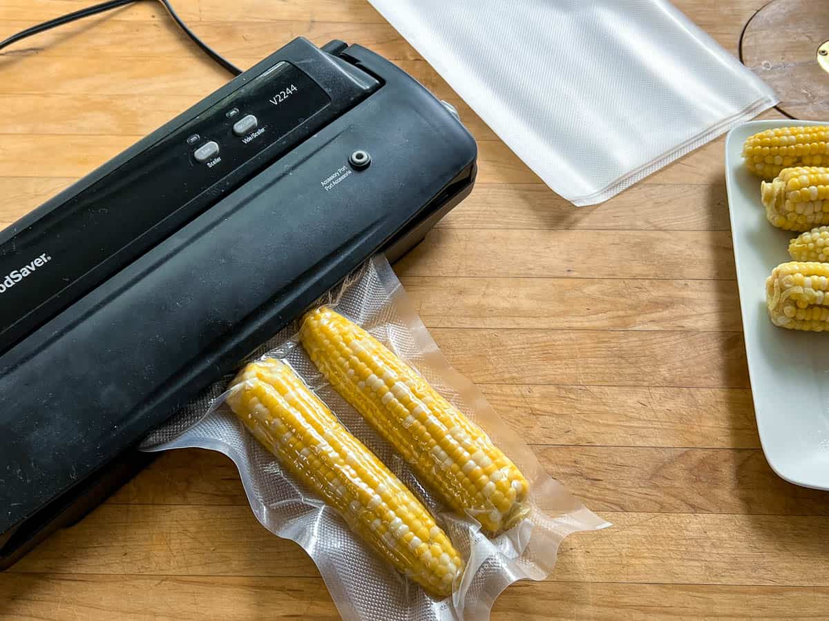 Corn on the cob being preserved with a vacuum sealer. 
