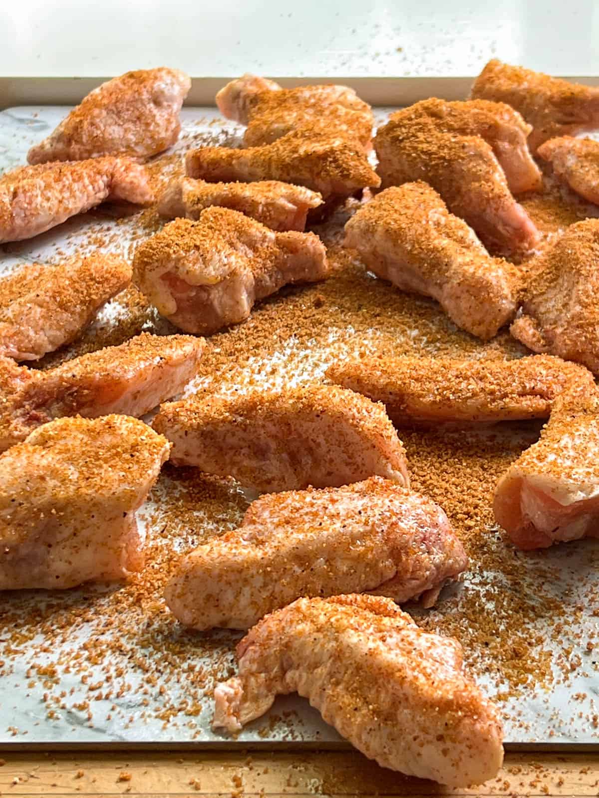 Raw chicken wings covered in dry rub.