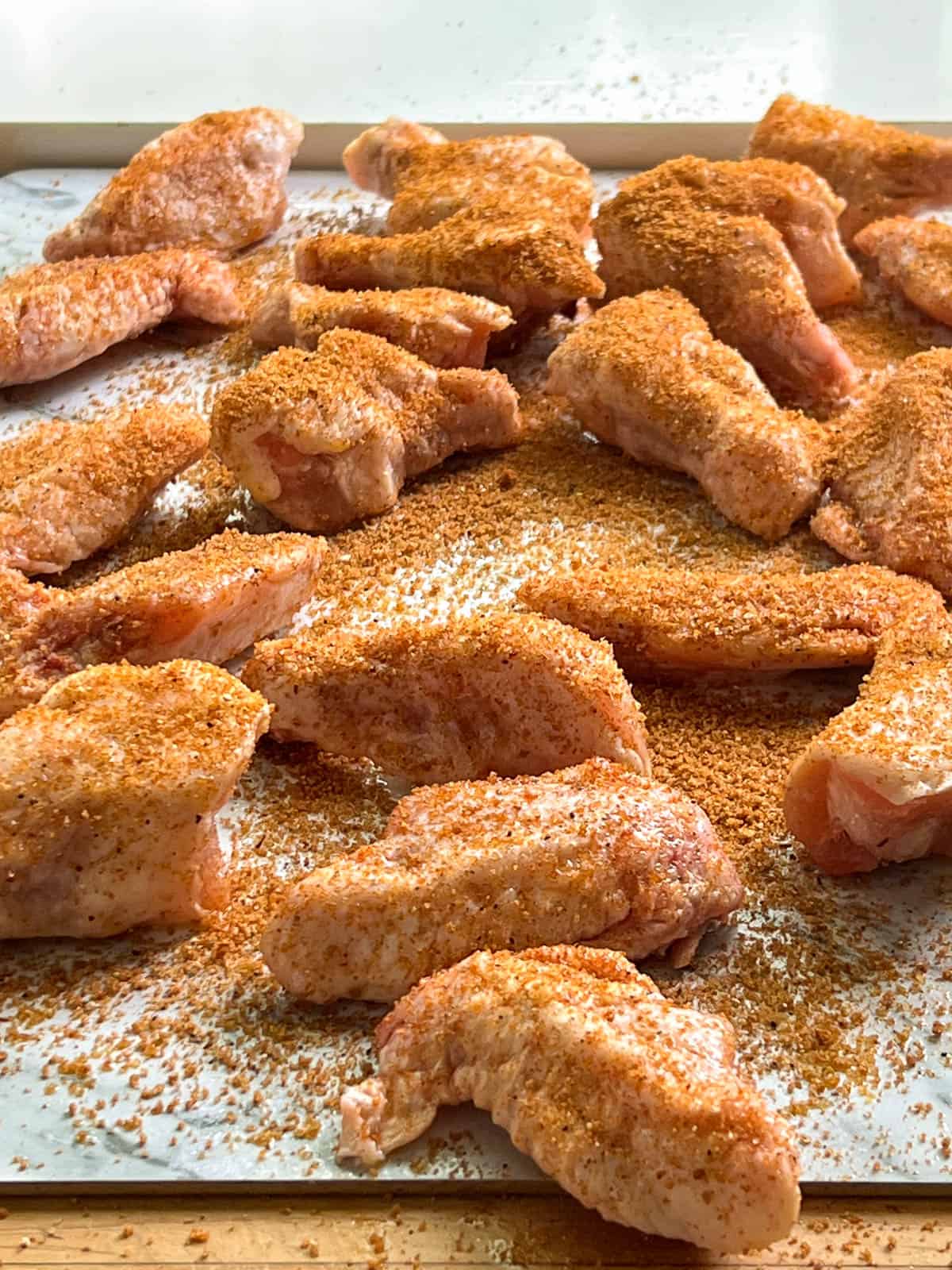 Raw chicken wings covered with dry rub.