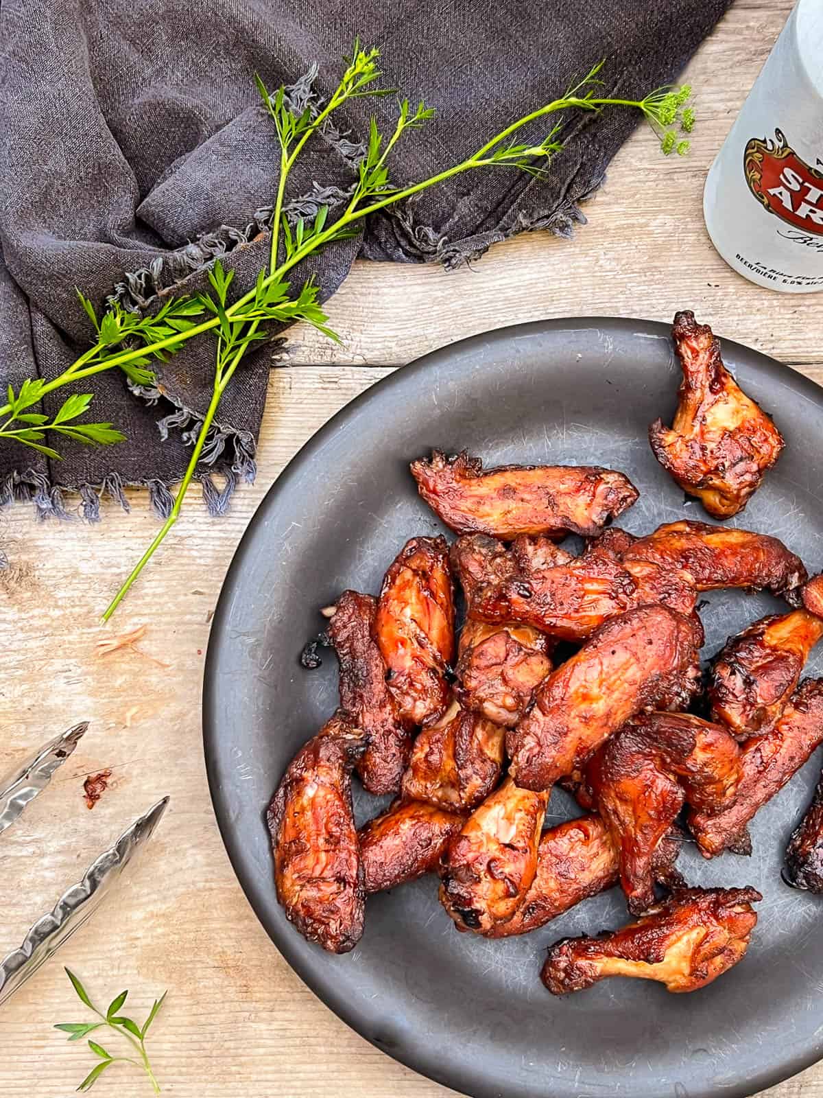 Smoked chicken wings on a black plate.