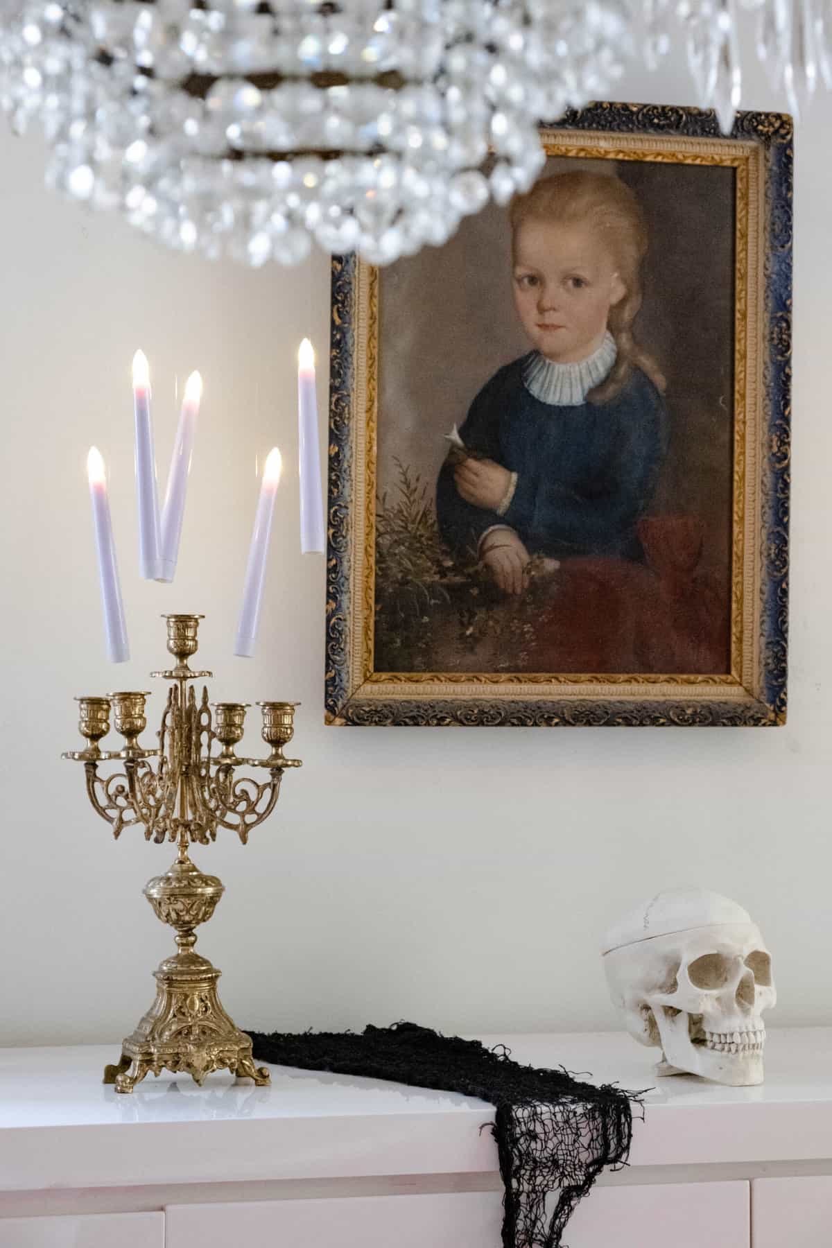 Candles floating in the air over brass candelabra with skull to the side.