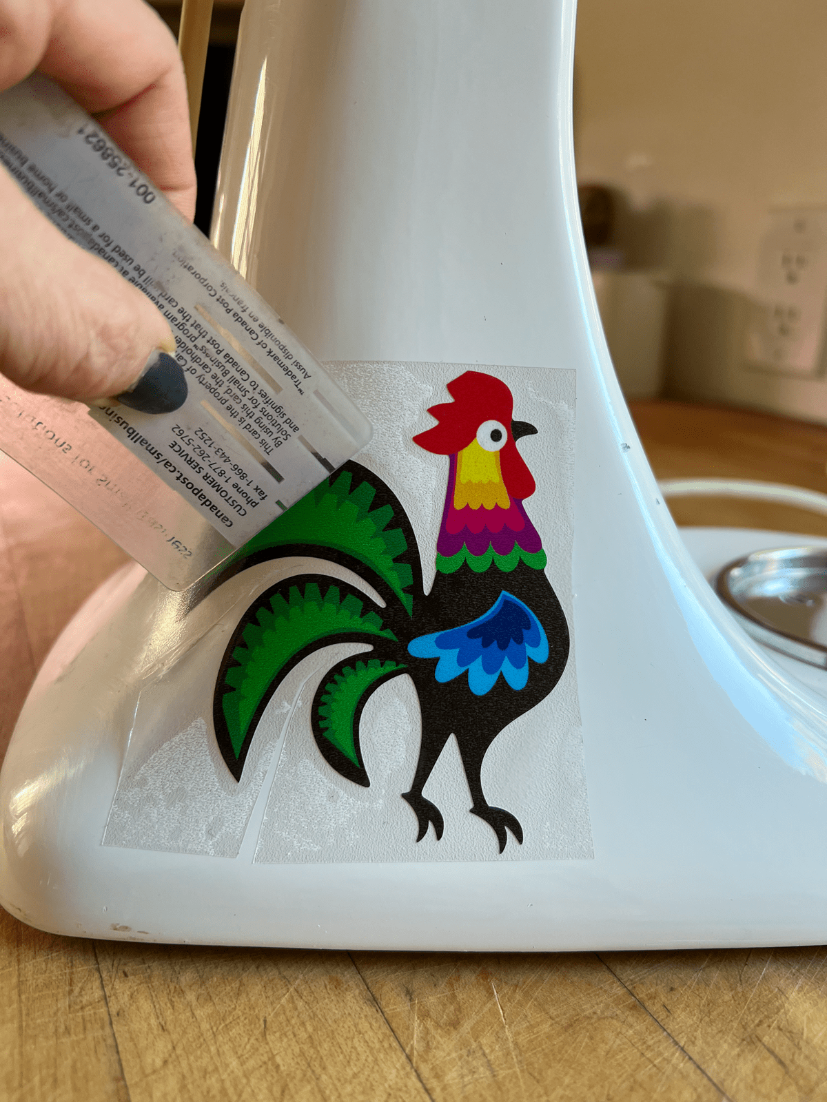 Applying vinyl decal to stand mixer.