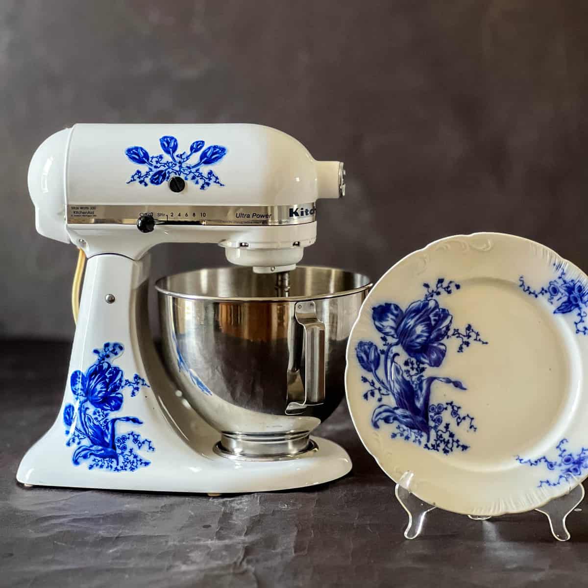 Kitchen aid with a blue tulip decal beside a flow blue plate the same  blue tulip.