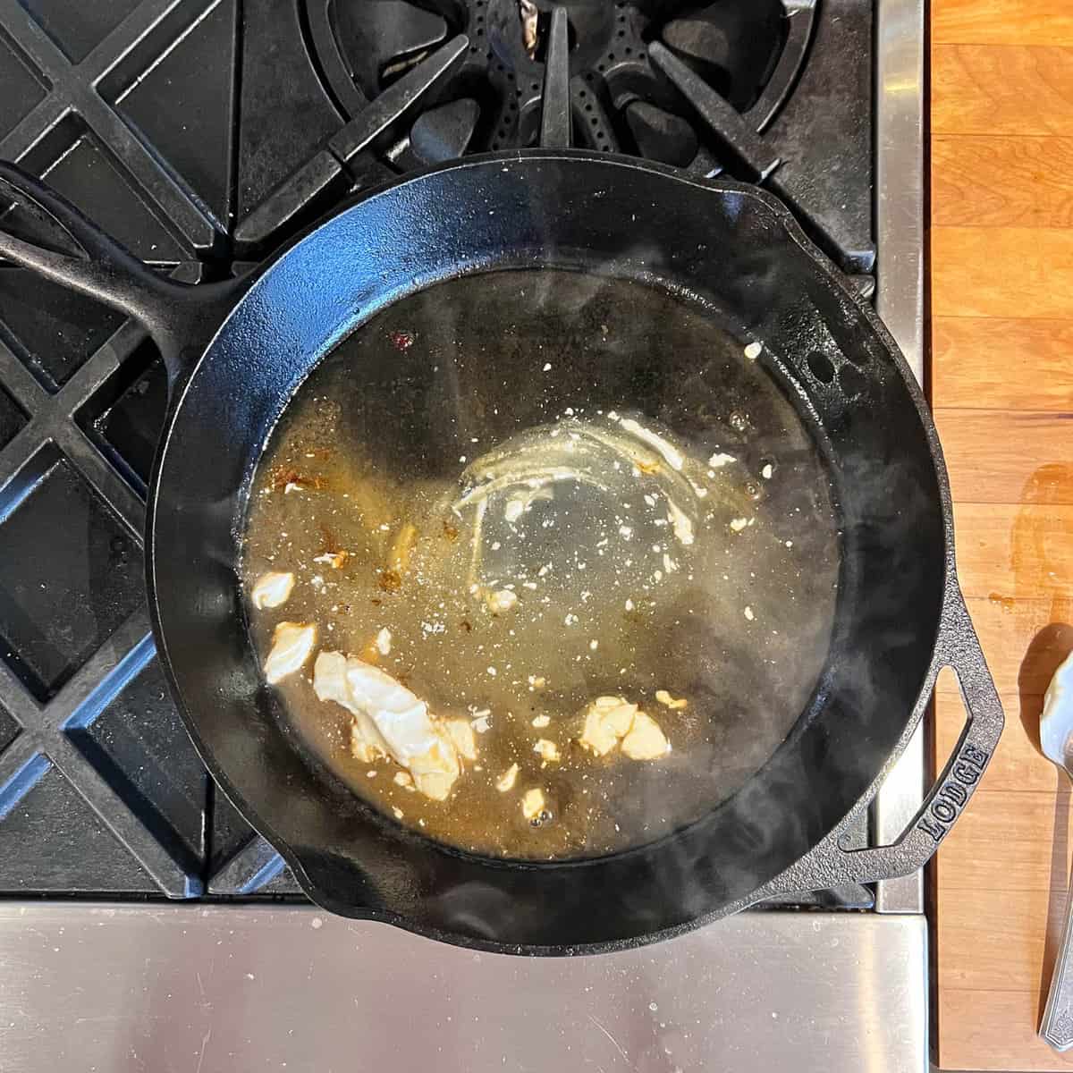 Sour cream sauce being prepared in cast iron pan.