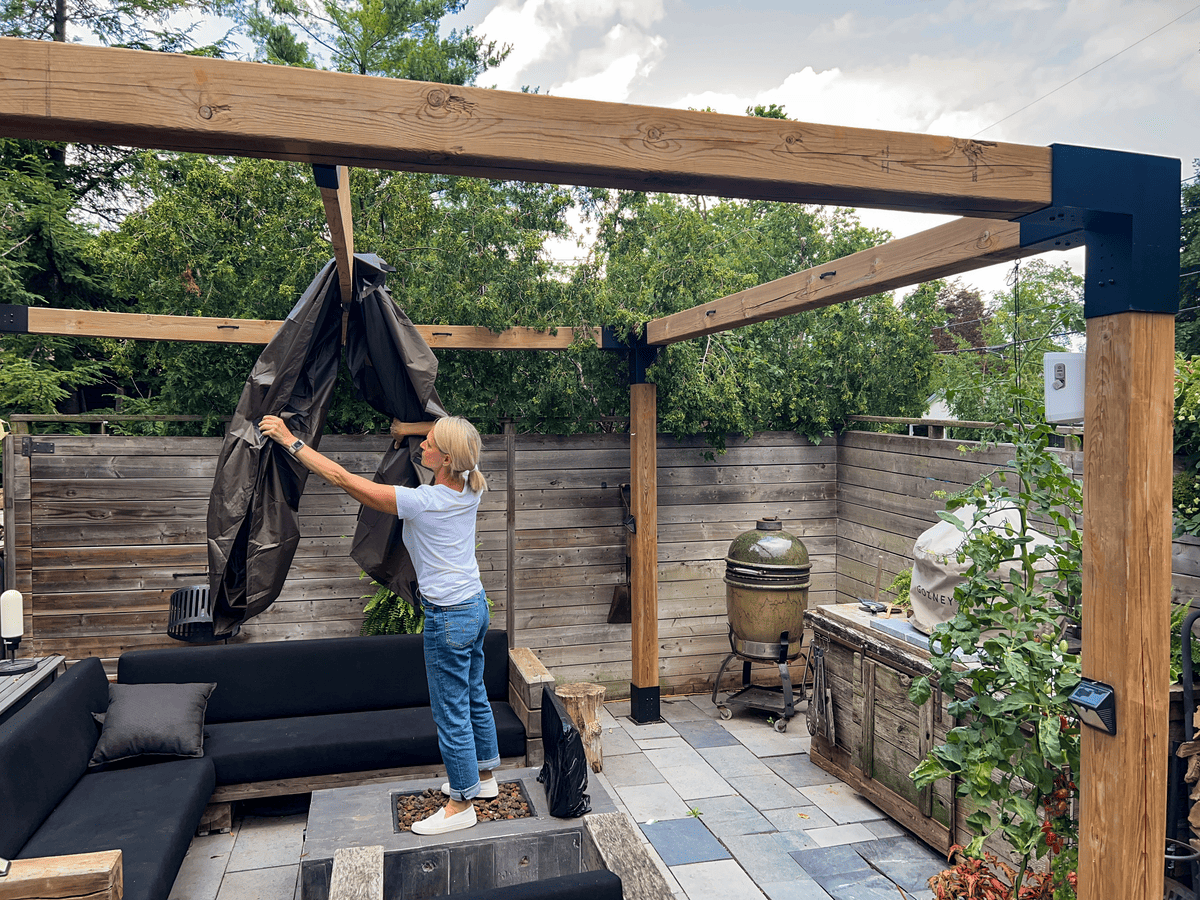 Karen Bertelsen draping fly tent over pergola centre support.