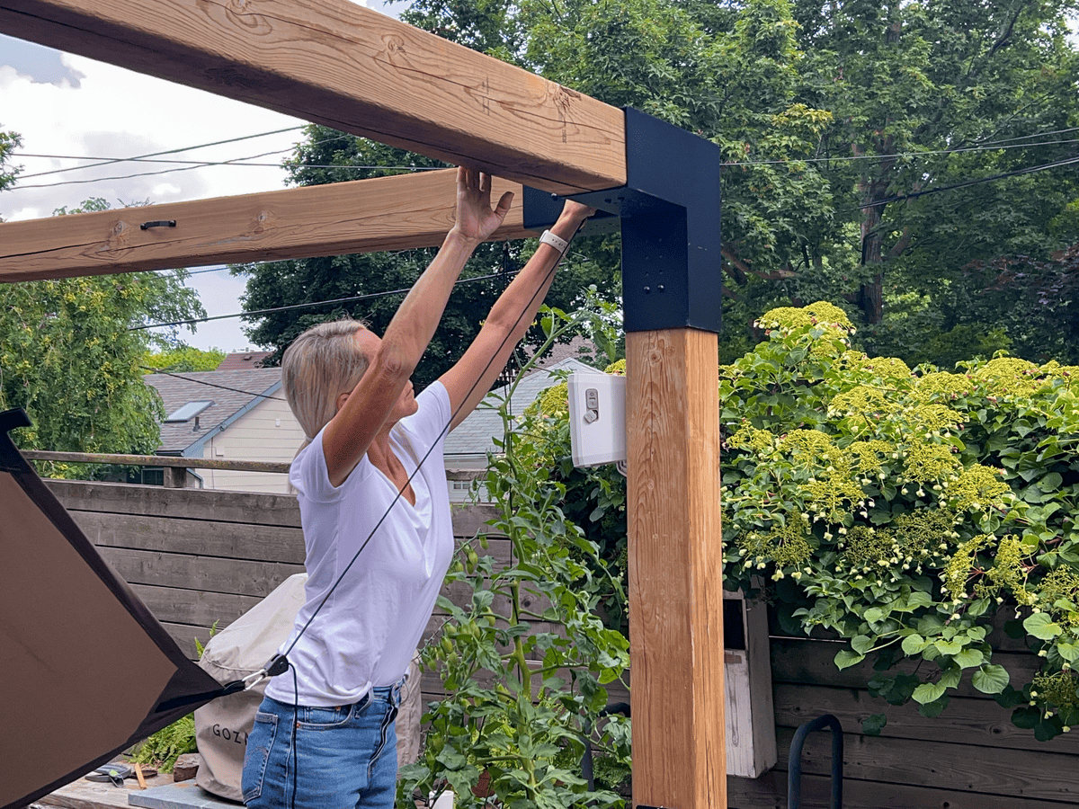 Karen Bertelsen clamping pulleys to pergola cover and pergola.