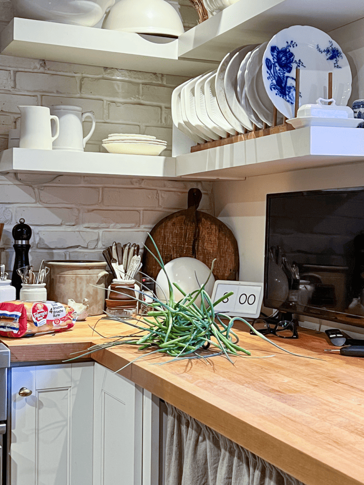 Country kitchen with garlic scapes on butcher block countertop.