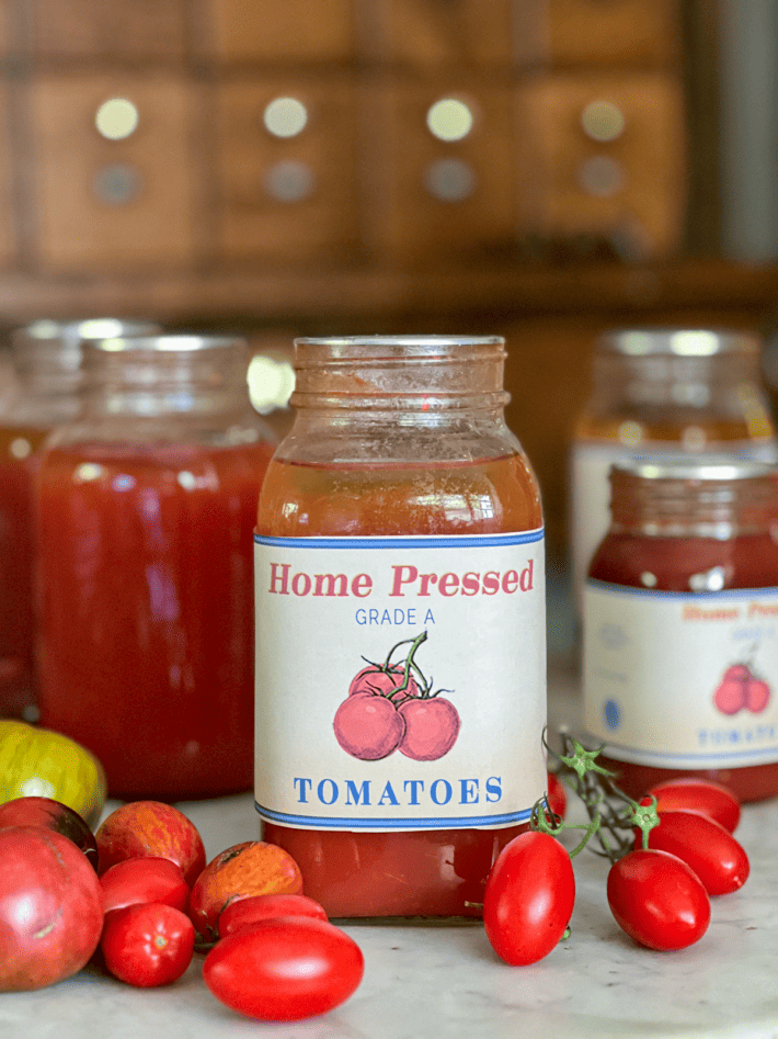 Tomato canning label on jar with tomatoes scattered.