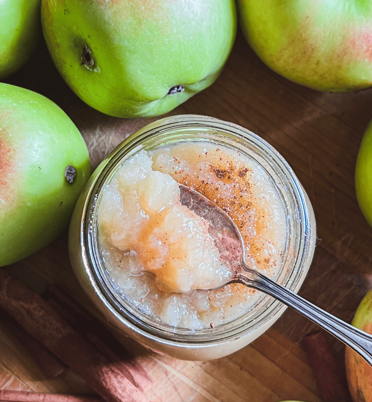 Homemade applesauce in a mason jar with sprinkled cinnamon.
