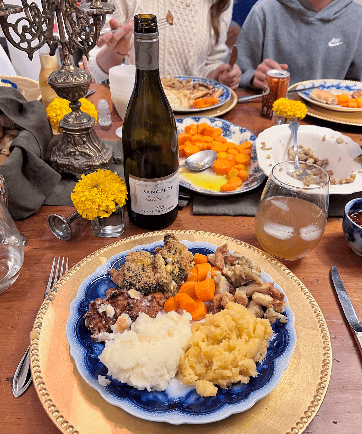 The vegetarians plate at thanksgiving dinner is full with mashed potatoes, rutabaga, sweet potato casserole, fresh carrots, stuffing (cooked outside of the turkey) and a bottle of Sancerre wine.
