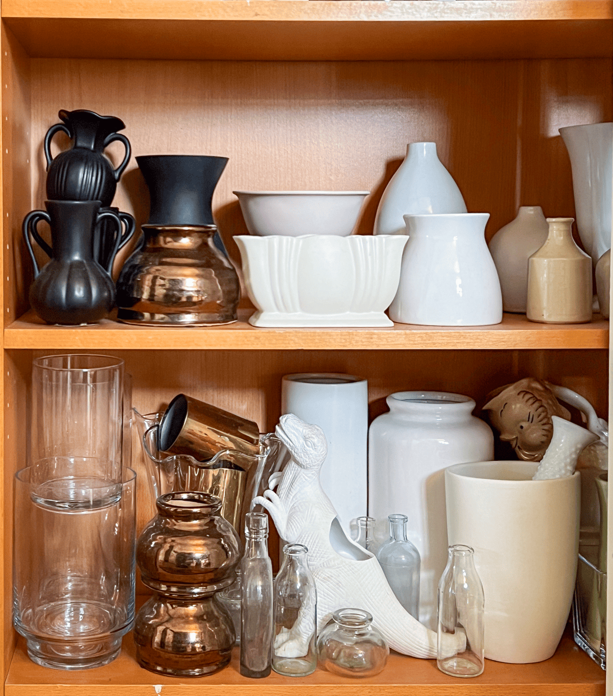 2 shelves inside an Ikea unit filled with flower vases.