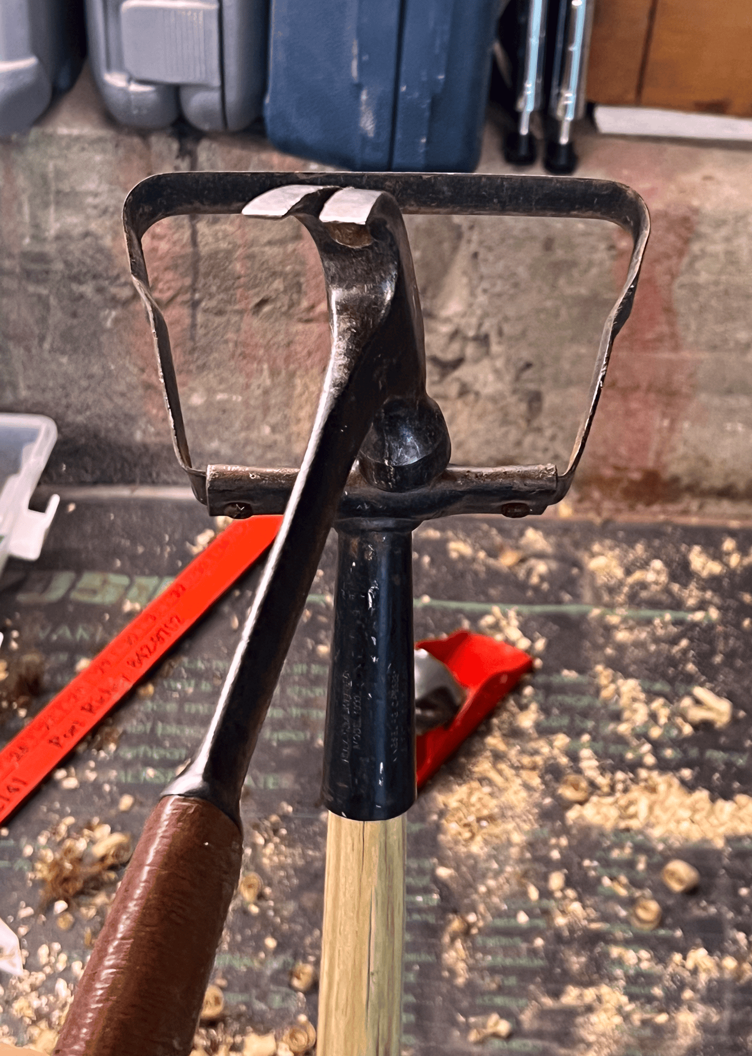 Setting a hula hoe head onto a new handle using a hammer.