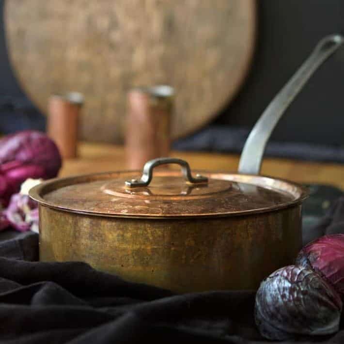 A copper pot and lid showing a warm patina from use.