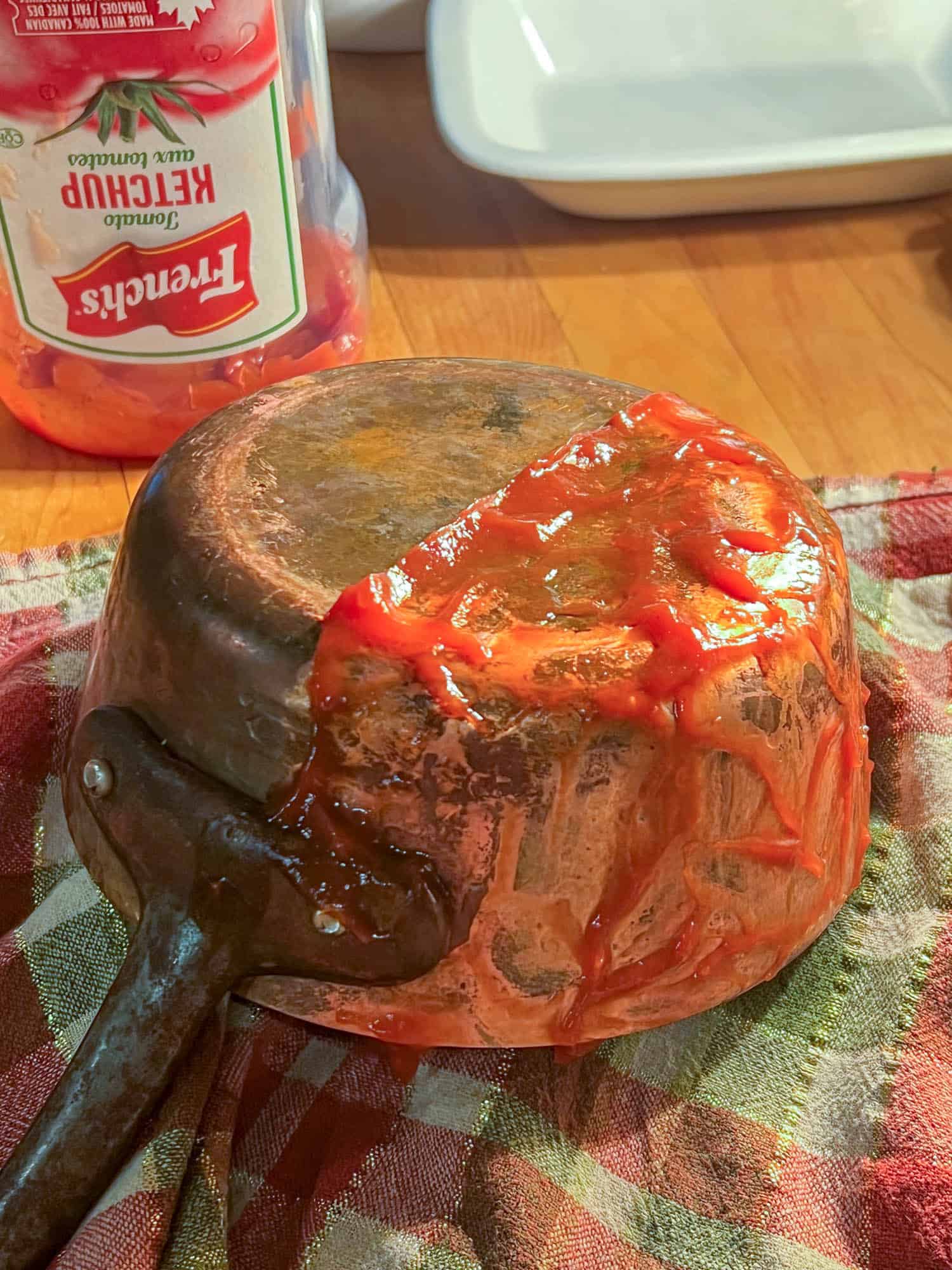 A copper pot being cleaned with the ketchup method but with no buffing.