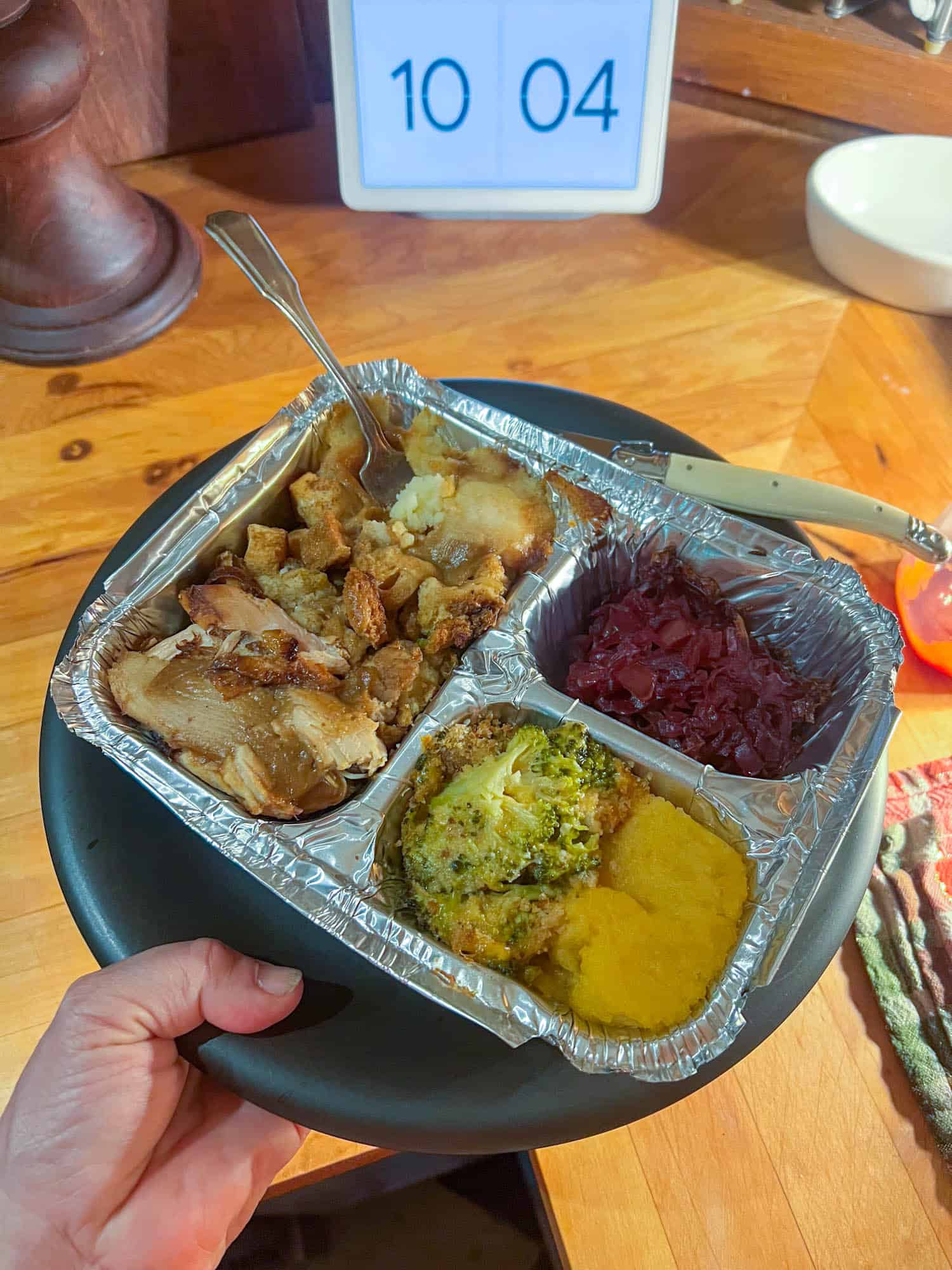 A homemade tv dinner in foil, sitting on a black plate.
