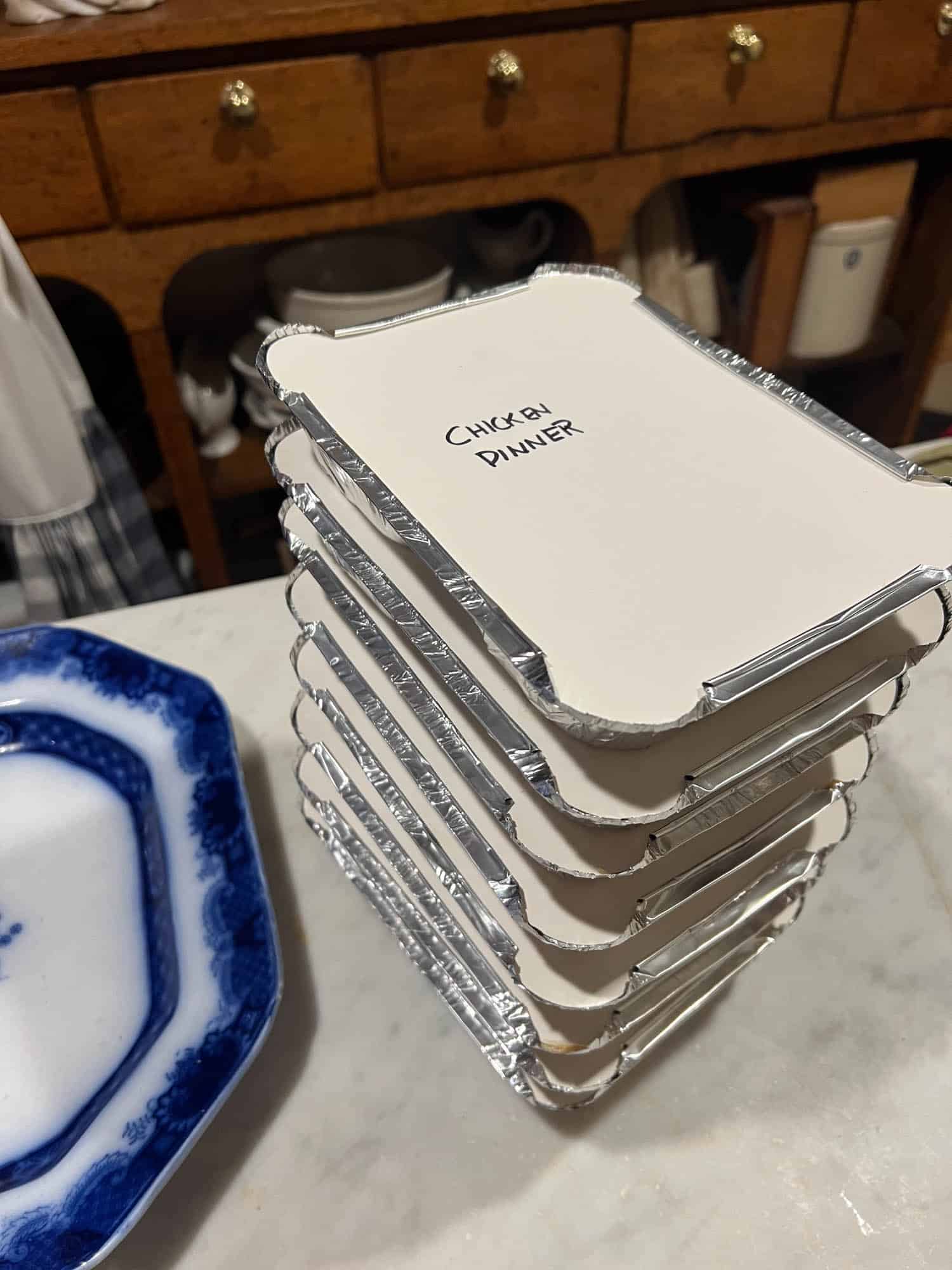 A tall stack of homemade frozen tv chicken dinners in foil.