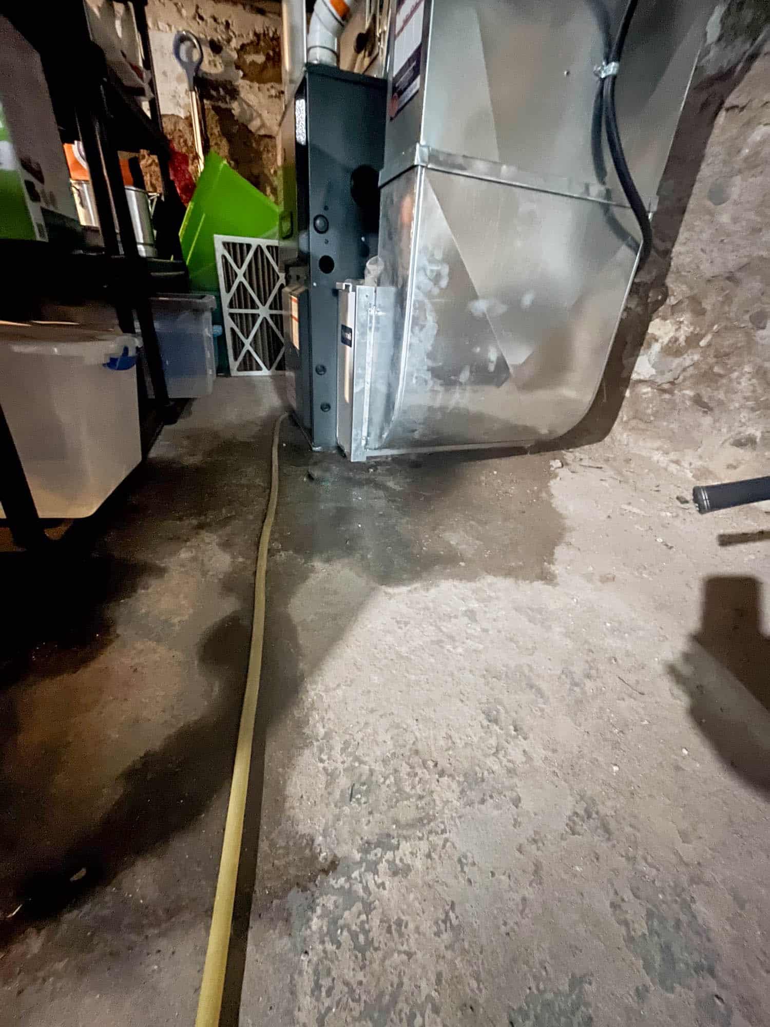 High Efficiency furnace/AC unit in old basement, leaking water onto cement floor.