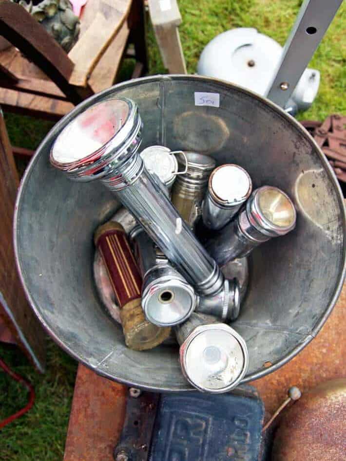 Galvanized bucket filled with vintage flashlights.