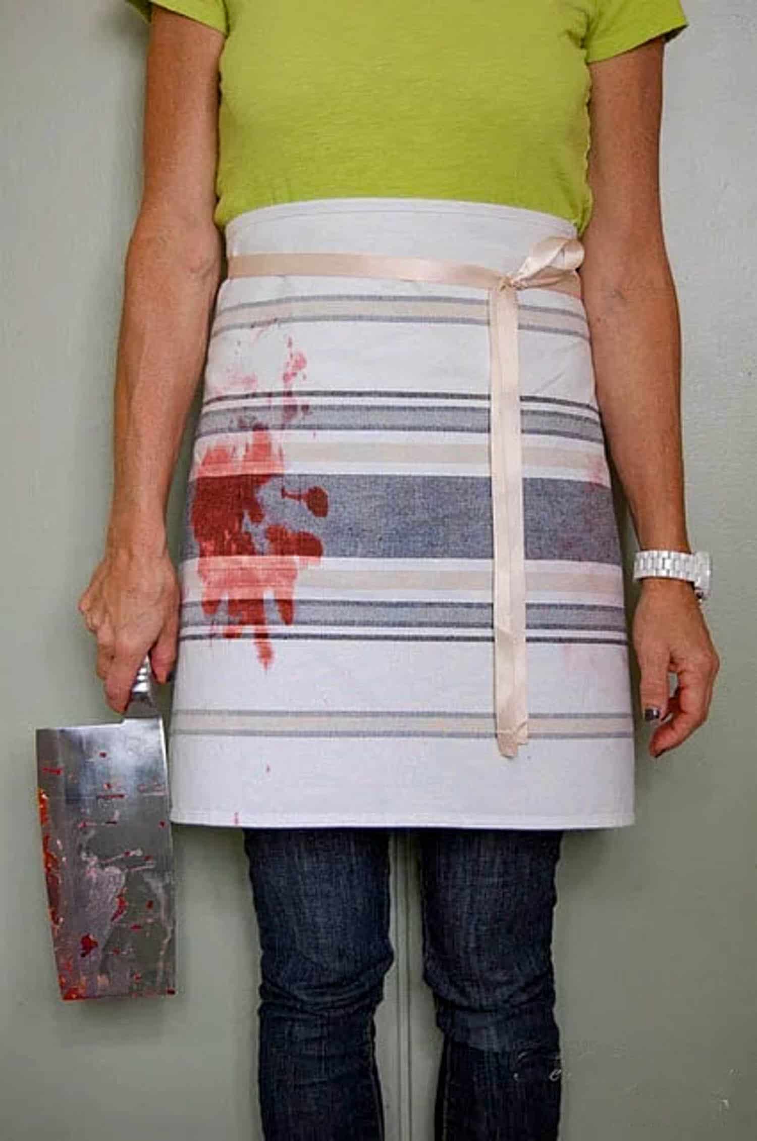 A half apron made of a tea towel, tied at the waste with bloody handprint.