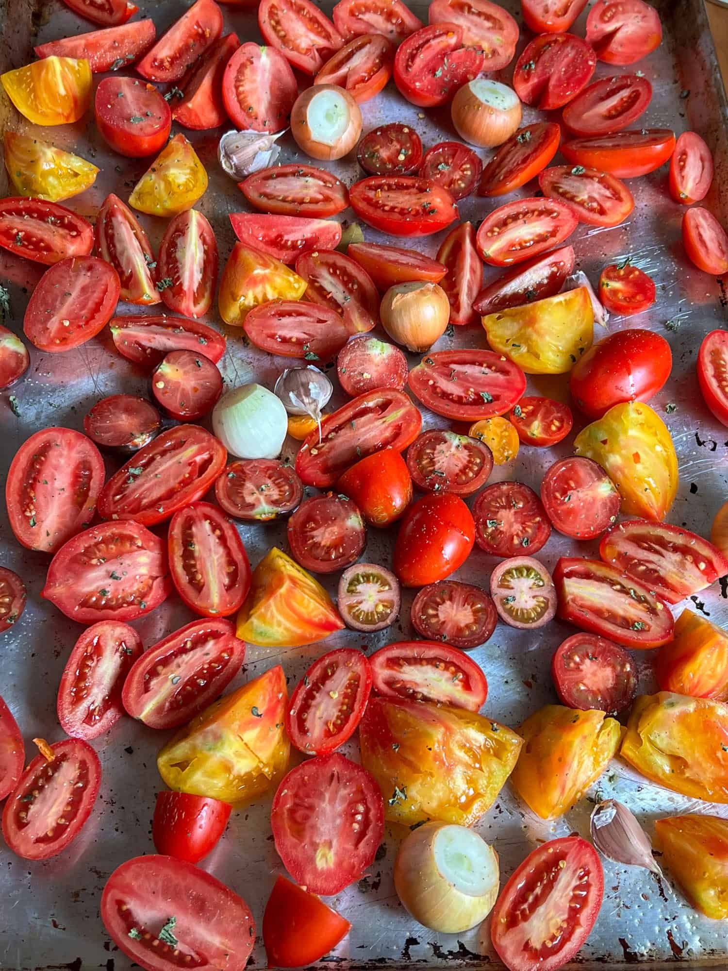 A sheet pan filled with sliced tomatoes for roasting.