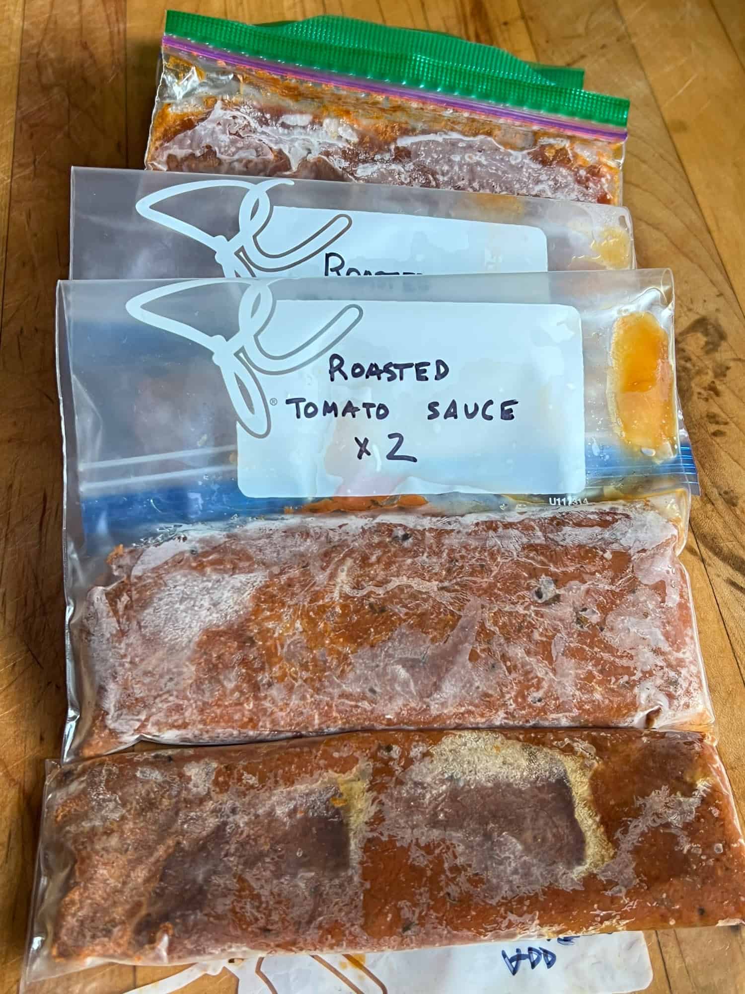 Roasted tomato sauce in icy freezer bags.