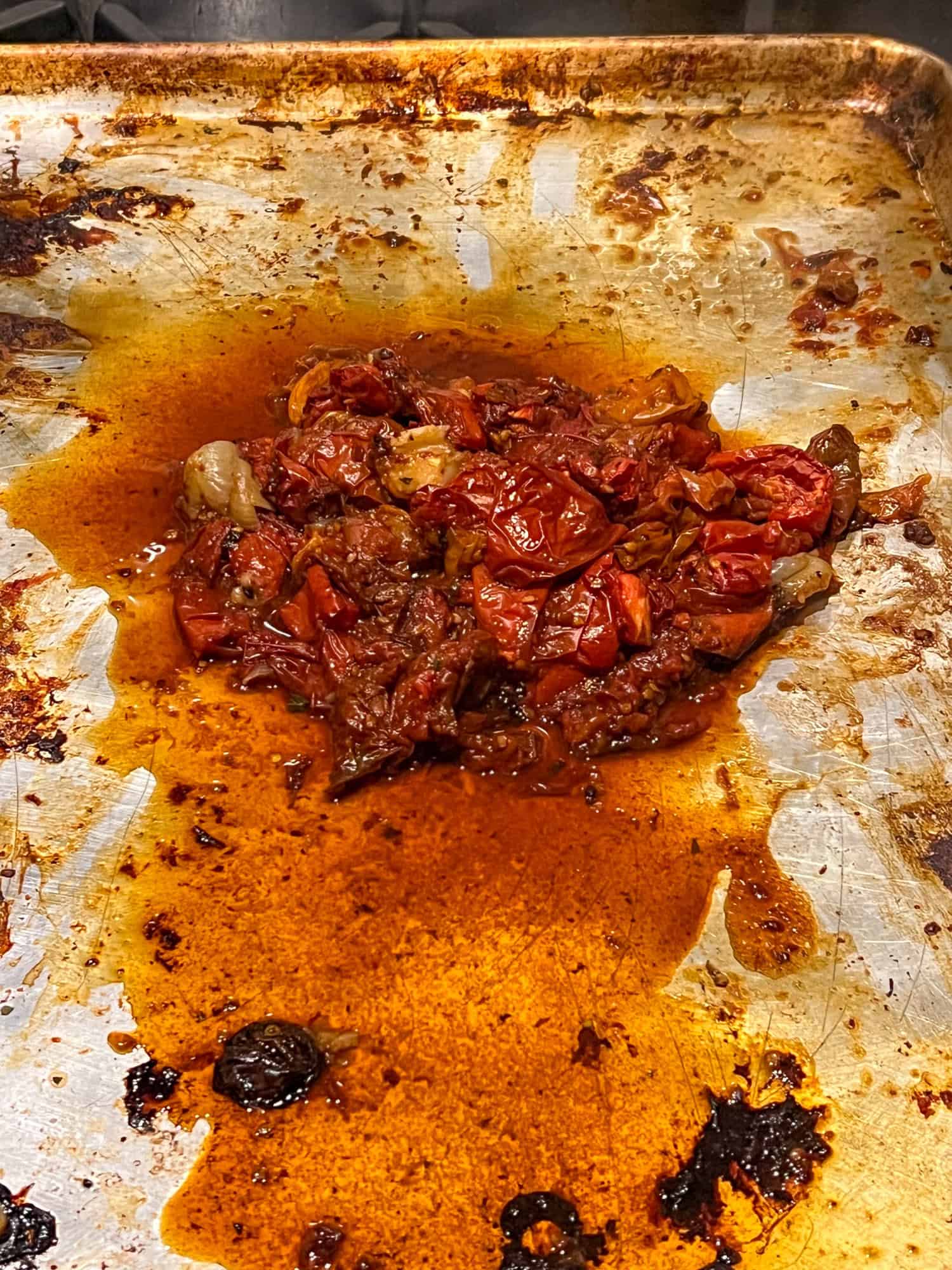 Roasted tomatoes on a deglazed sheet pan.