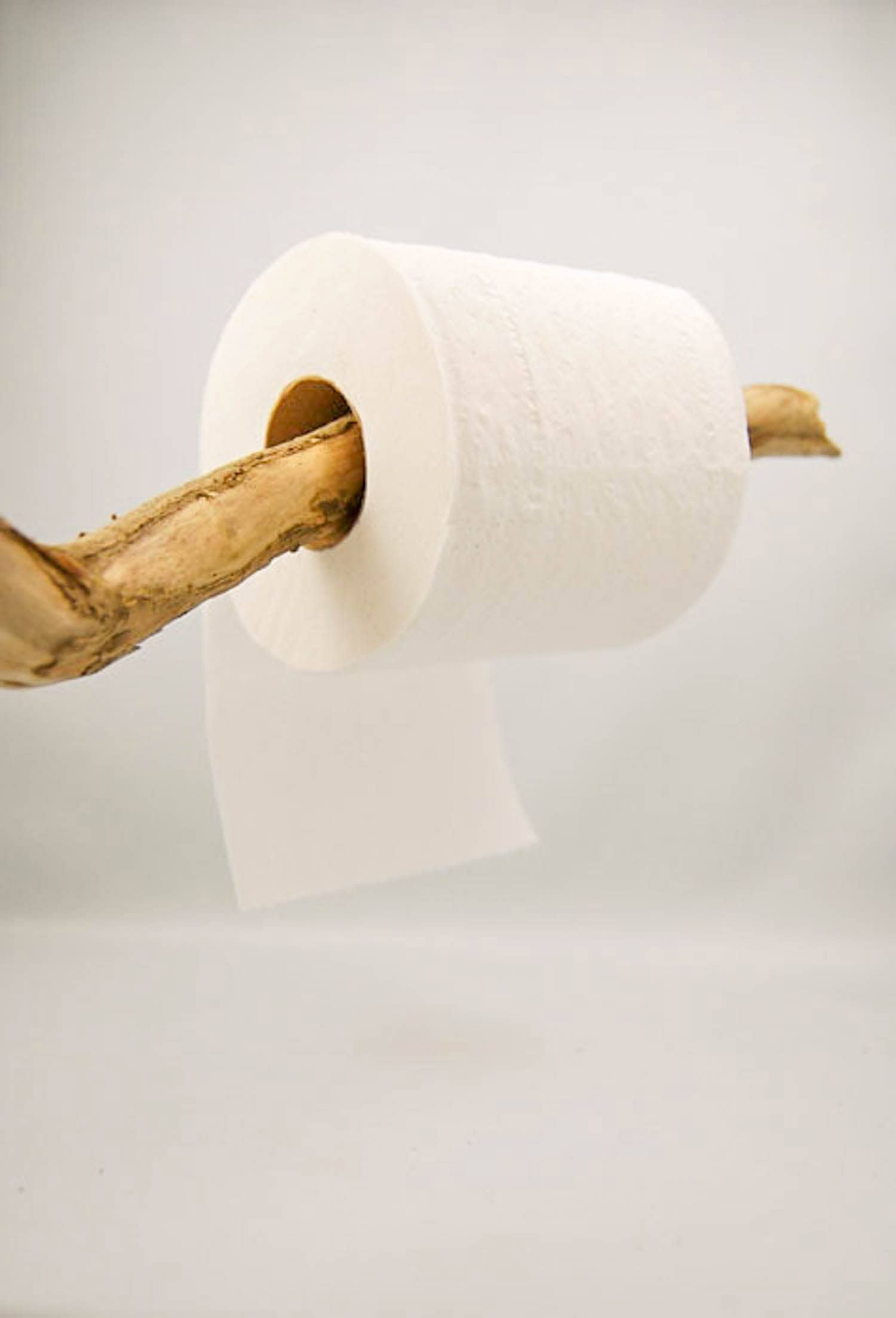 Toilet paper rolling under on a stick.