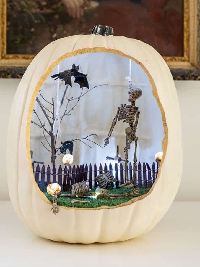 Foam pumpkin diorama with bats, trees, skeletons and picket fence.